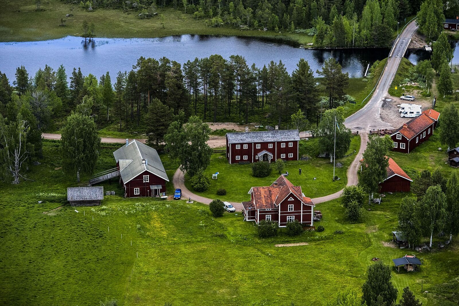 Fågelsjö Gammelgård från luften, med byvägen och Fågelsjön bakom.
